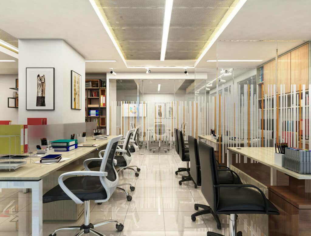 Bureau moderne avec des rangées de bureaux et de chaises, des cloisons en verre, des étagères avec des dossiers et des livres, et des œuvres d'art sur le mur ; éclairage lumineux et espace de travail propre et organisé - idéal pour agencement bureaux Île-de-France ou rénovation commerces Paris.