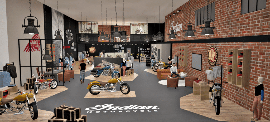 Une vaste salle d'exposition Indian Motorcycle avec des murs en briques, des éclairages de style ancien, des motos exposées, des marchandises et des gens qui parcourent le magasin.