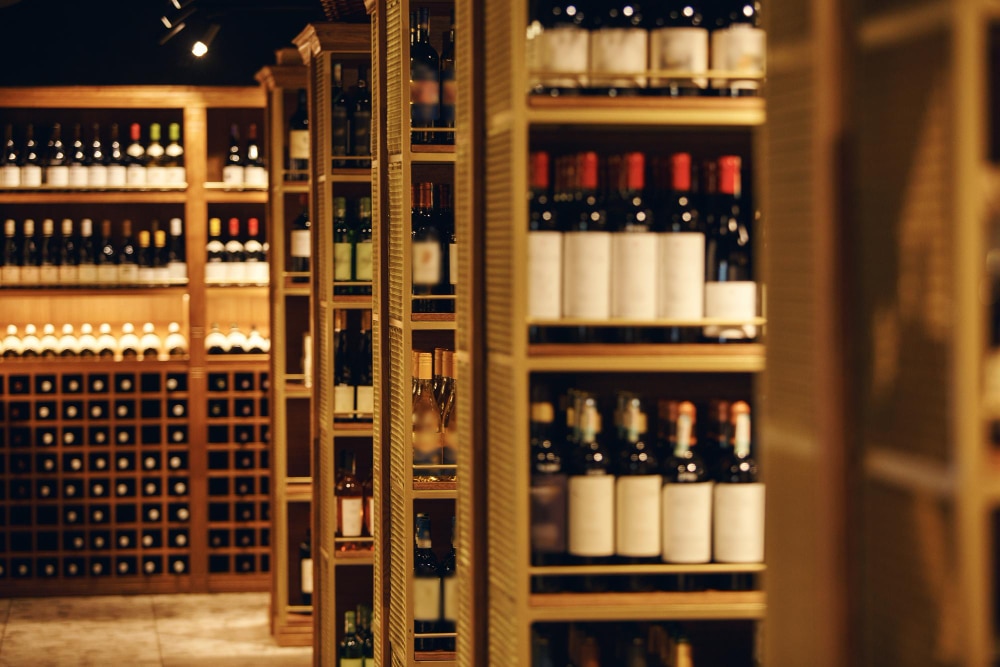 Une cave à vin avec plusieurs étagères remplies de bouteilles de vin.