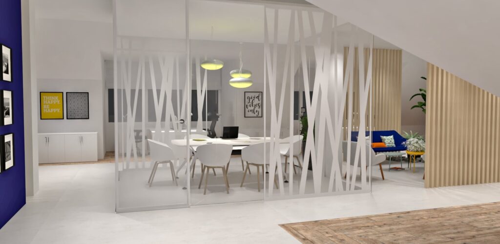 Salle de réunion de bureau moderne avec des murs en verre, des chaises blanches autour d'une table, des lampes suspendues au-dessus, et un coin salon avec des plantes et des coussins décoratifs à l'arrière-plan.