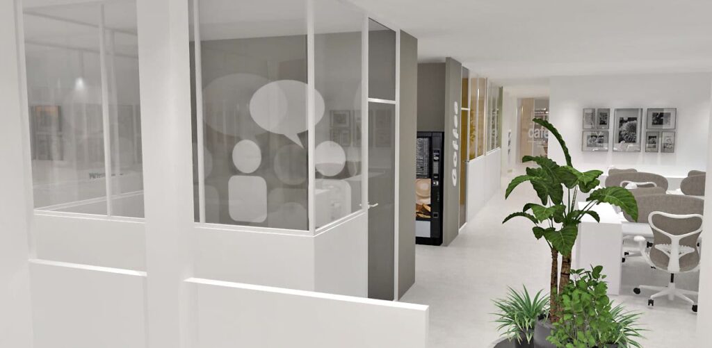 Espace de bureau moderne avec salle de réunion vitrée, distributeur automatique, plusieurs bureaux avec des chaises, des plantes d'intérieur et des photos encadrées au mur.