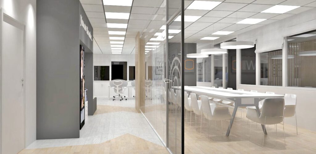 Espace de bureau moderne avec une salle de conférence vitrée, des tables et des chaises blanches, un éclairage zénithal et de grandes fenêtres.
