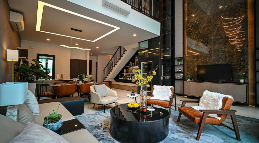 Salon moderne à aire ouverte avec mobilier contemporain, table basse en verre, plantes décoratives et escalier menant à l'étage supérieur. Tons neutres, éclairage d'appoint et grandes fenêtres.